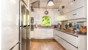 Eine moderne Küche mit weißen Schränken, Edelstahlgeräten und Holzboden.