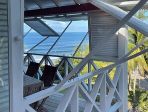 A covered outdoor seating area with a view of the ocean.