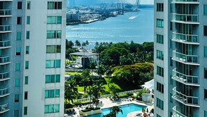 Un edificio alto con vista a un puerto deportivo y una extensa masa de agua.
