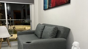 A modern living room with a grey sofa, a black side table, and a white bust sculpture. - 5 minutes from the beach and pool (manzanillo)