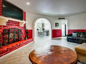 Una sala de estar con chimenea, un sofá y una mesa de centro redonda.