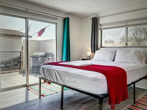 Un dormitorio con cama, ventana y vista al exterior.