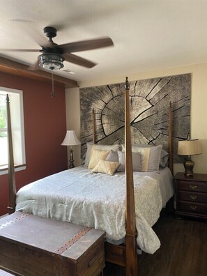 Restful retreat with a four-poster bed and canopy, accompanied by a statement piece of art and a comfortable bench.