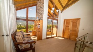 A spacious living area with a wooden bench, a bookshelf, and a view of the outdoors.
