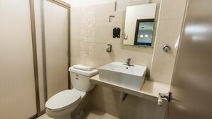A small, clean bathroom with a toilet, sink, and mirror. - Hotel Boutique 5ta avenida (Córdoba)