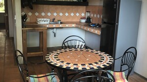 Eine Küche mit einem runden Tisch, Stühlen und einem Kühlschrank.