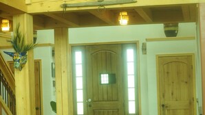 A wooden door with a small window, a wooden staircase, and a hanging decorative item.