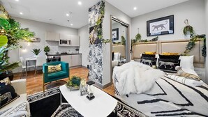 A modern living room with a sofa, a dining area with chairs, a kitchen with cabinets and a microwave, and a bedroom with a bed and a headboard. - Luxury 1bed Studio Apt-city Centre-wifi-parking (Maidstone)