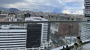 A high-rise building with a view of a cityscape, including various buildings and a mountain in the distance. - Luxury suite 16th floor of the best building in Quito (Quito)