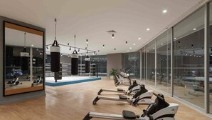 A gym with cardio machines, a punching bag, and a large mirror. - Luxury suite 16th floor of the best building in Quito (Quito)