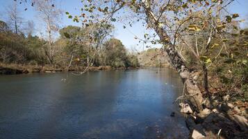 A calm river with trees and a rocky bank.
