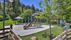 A playground with slides and a small shelter, surrounded by grass and trees. - Cozy Deadwood Escape < 1 Mi to Dtwn & Casinos (Deadwood)