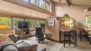 A spacious living area with a large window, a ceiling fan, a television, a sofa, and a dining area. - Golfing, Hot Tub & Pool, A/C, Pickle Ball, Hiking! (Durango)