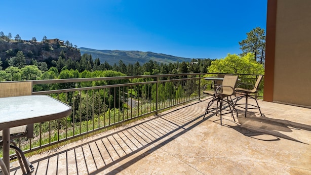 A balcony with a table and chairs, overlooking a mountainous landscape with trees and a clear sky. - Golfing, Hot Tub & Pool, A/C, Pickle Ball, Hiking! (Durango)