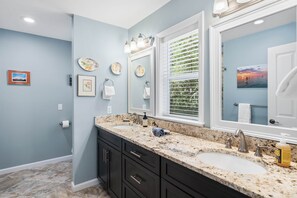 A bathroom with two sinks, dark cabinets, a large mirror, and a window with blinds. - Stella Luna 1, Old Grayton, 2 bed 2 bath (Walton County)