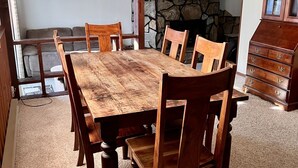 A dining area with a wooden table and chairs, a stone wall, and a wooden cabinet. - Roomy three bedroom home with Boat/RV parking (Coulee Dam)