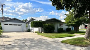 A residential street with two houses, a driveway, and a sidewalk. - Roomy three bedroom home with Boat/RV parking (Coulee Dam)