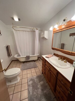 Une salle de bain comprenant des toilettes, une baignoire et un lavabo.