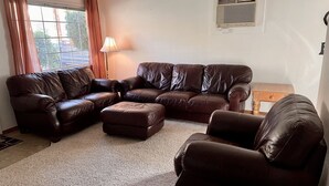 A living room with a sectional sofa, a single armchair, and a lamp. - Roomy three bedroom home with Boat/RV parking (Coulee Dam)