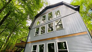 A two-story building with multiple windows and a balcony. - Fully Renovated Cabin in Hocking Hills - Hot Tub, Game Room, Wifi, Fireplace (Amanda)