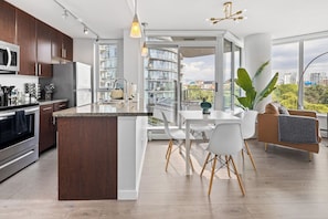 Enjoy a spacious kitchen with a central island, dining area, and comfortable living space with a city view.