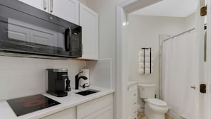 A compact kitchen with a microwave, coffee maker, and a sink. - La Dolce Vita Studio (Port St. Lucie)