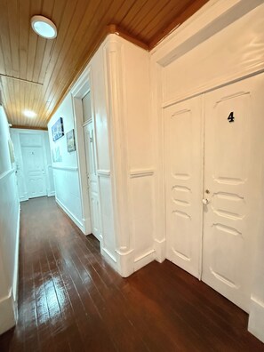 A hallway with wooden flooring, white walls, and doors numbered 1 and 4. - Lisboa Parque Guest House (Lisbon)