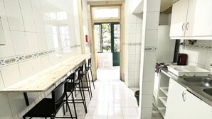 Una cocina con una encimera larga, sillas y un lavamanos.