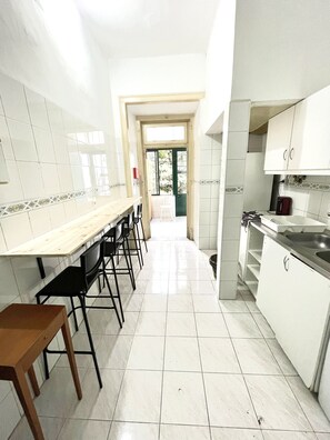Une cuisine avec un long comptoir, des chaises et un évier.