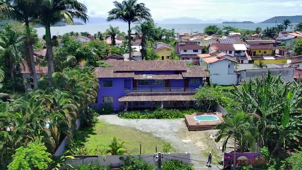 A residential area with houses, a swimming pool, and lush greenery. - Pousada Tropicália Paraty (Paraty)