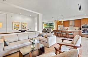 A modern living room with a sofa set, a coffee table, and a dining area with chairs. - Maui Resort Rentals: 6 Total Bedrooms at Kaanapali’s Newest Luxury Residences, Steps from Beach & Resort Amenities! (Lahaina)
