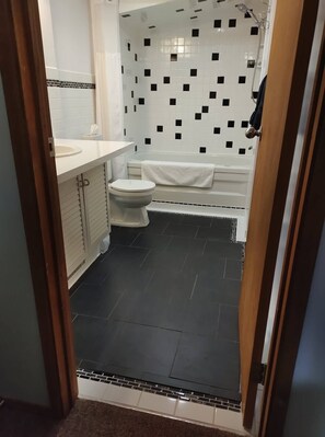 A bathroom with a toilet, sink, and bathtub. - Kitchenette Suite with King & Queen beds, Quiet Forest views from patio with BBQ (Hinton)
