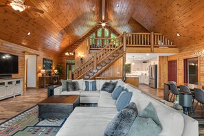 Cozy cabin-style lodging features a spacious living area, kitchen, dining space, and flat-screen TV.