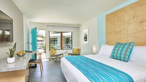 A modern hotel room with a bed, a desk, and a view of the outdoor pool area. - Twin Palms Resort - A Gay Men's Resort (Palm Springs)