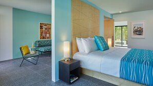 A modern bedroom with a bed, a chair, a nightstand, and a window. - Twin Palms Resort - A Gay Men's Resort (Palm Springs)