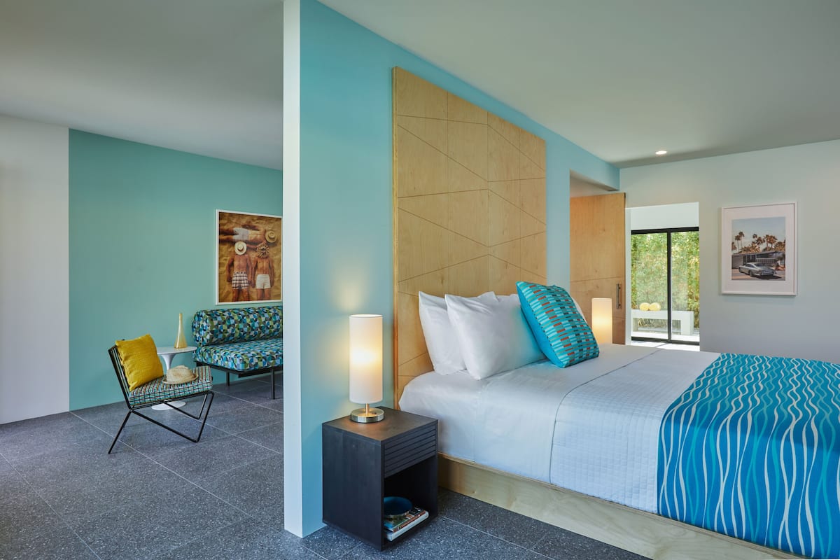 Een moderne slaapkamer met een bed, een stoel, een nachtkastje en een raam.