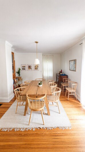 A dining area with a wooden table and chairs, a hanging light fixture, and framed pictures on the walls. - Family Lake Getaway on Davis Stream  5BR + Kayaks (Jefferson)