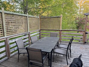 Una terraza de madera con una mesa y sillas, rodeada por una valla de madera.