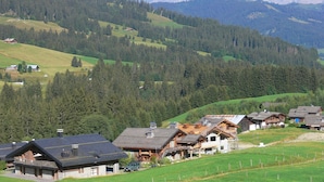 A mountain village with traditional wooden houses, a ski lift, and a view of distant mountains. - Au Soleil De Megève 750m From Ski, Megeve (Chamonix), France (Megeve (Chamonix))