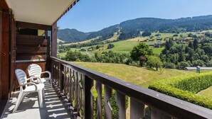 Un balcón con vistas a un valle verde y colinas.