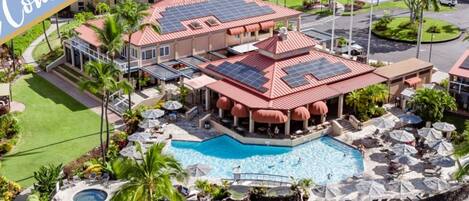 Um resort com vários edifícios, piscina e paisagismo exuberante.
