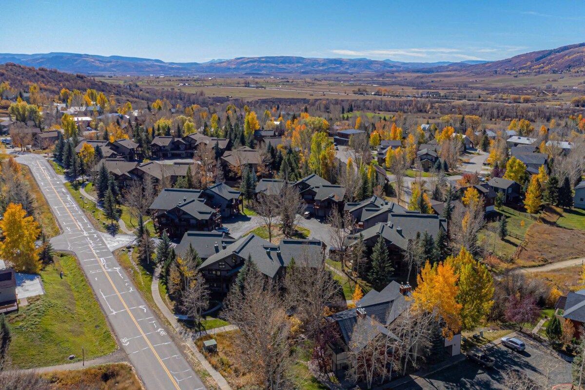 Un quartier résidentiel avec des maisons, des rues et un feuillage automnal.