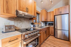 Una cocina moderna con armarios de madera, electrodomésticos de acero inoxidable y encimera de granito.