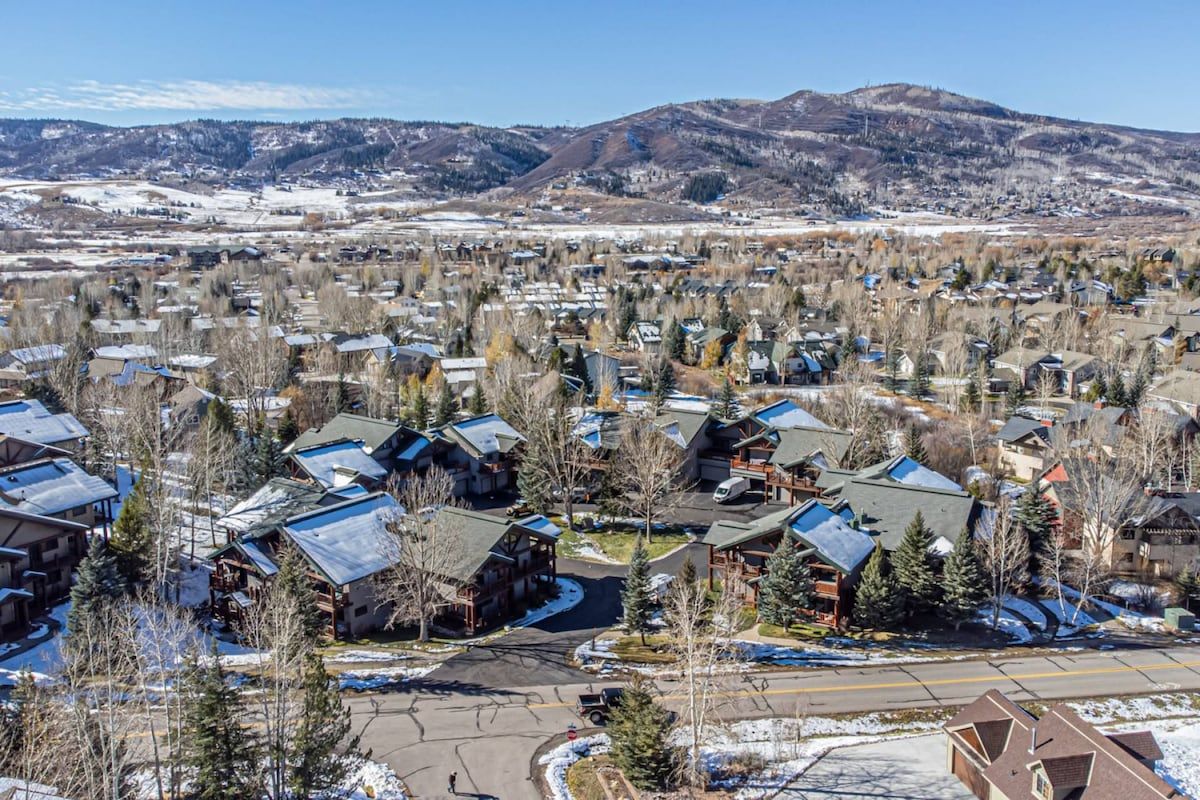 A residential area with houses, some with attached garages, and a clear view of the surrounding mountains.