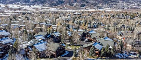 A residential area with houses, some with attached garages, and a clear view of the surrounding mountains.