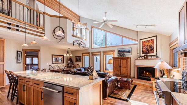 A spacious kitchen with a central island, wooden cabinets, and a built-in dishwasher.