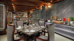 Un restaurante con paredes de mármol, techo de madera y una zona de bufé con diversos alimentos y condimentos.