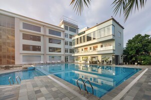 Una piscina con vistas despejadas a los edificios cercanos, incluyendo un hotel de varios pisos y diseño moderno.
