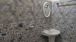 A bathroom with a sink, a mirror, and a hand dryer. - Homocation Panchami Homestay (Bokakhat)