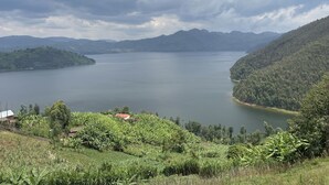 A lake surrounded by hills with a small building in the foreground. - Nice Rooms, Unbeatable Prices (Ruhengeri)